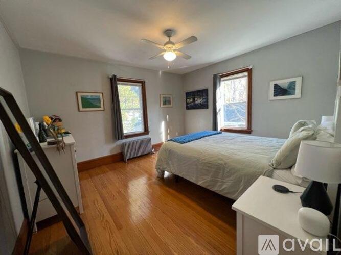 A bedroom with a bed, a dresser, and a painting on the wall.