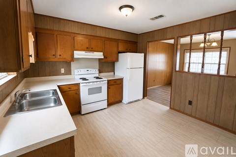 A kitchen with wooden cabinets and white appliances.