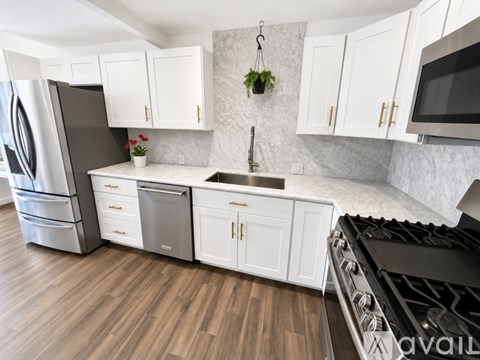 A kitchen with white cabinets and a black stove top.