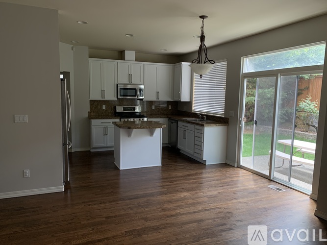 A kitchen with white cabinets and a wooden island.