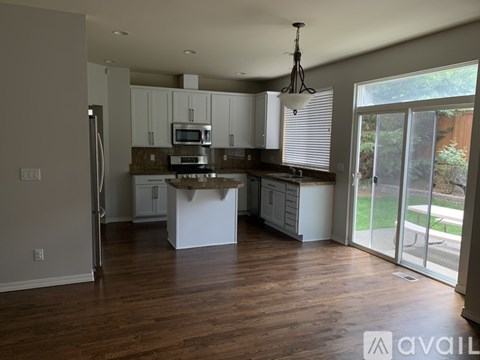 A kitchen with white cabinets and a wooden island.