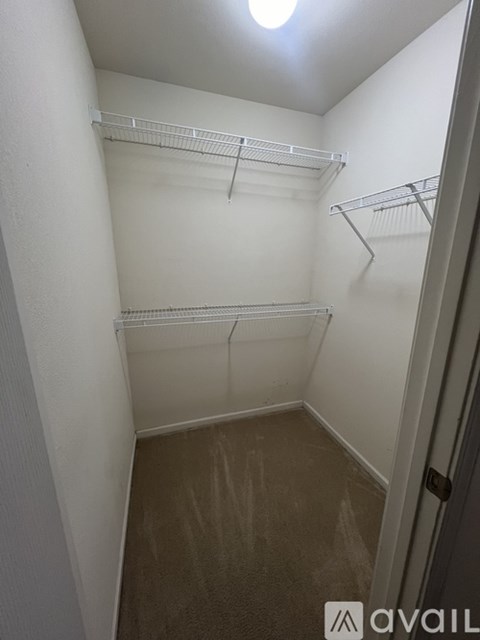 A small, empty closet with a white door and shelves.
