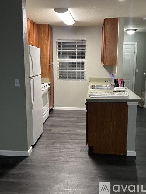 A kitchen with a white refrigerator and wooden cabinets.