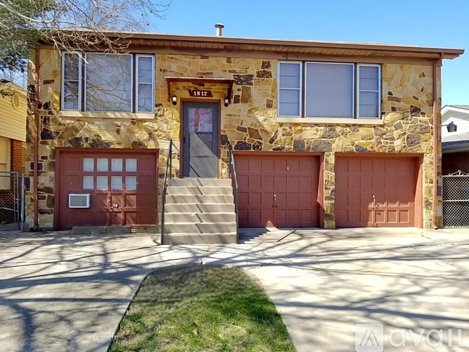 A house with a stone facade and a red garage door.