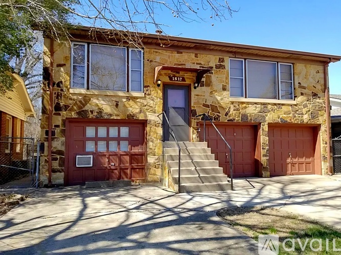 A house with a stone facade and a red door is for sale.