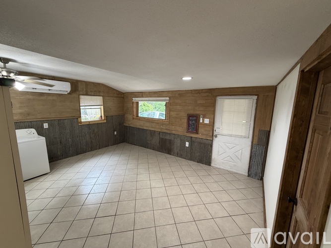 A room with a washing machine and a window.
