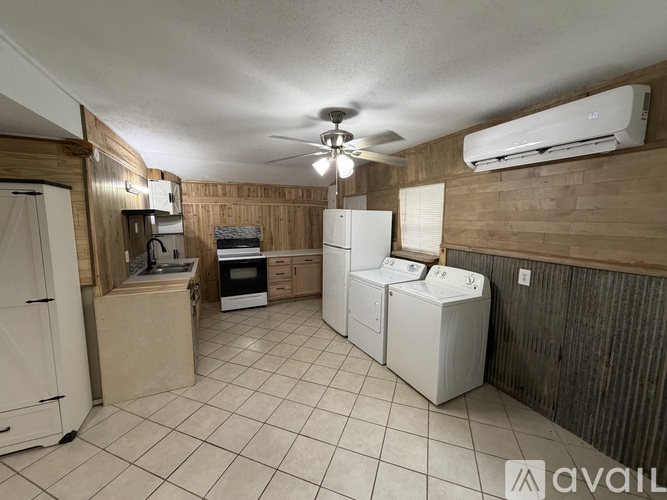A kitchen with a refrigerator, oven, and microwave.