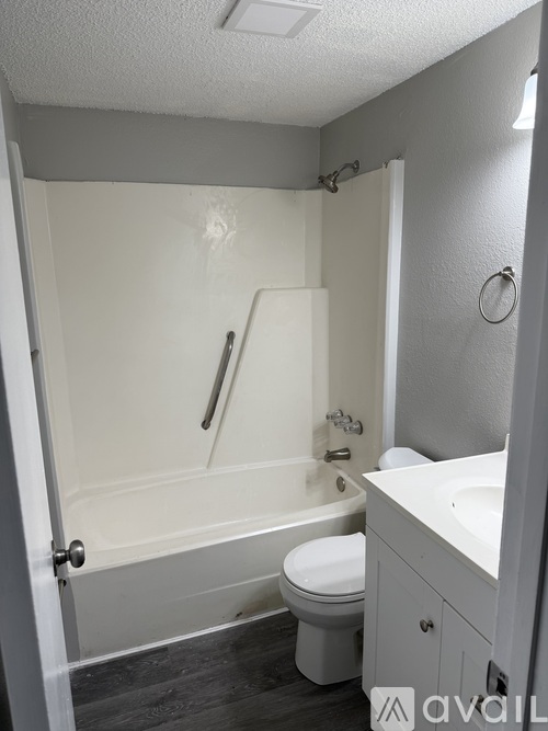 A bathroom with a toilet, sink, and bathtub.