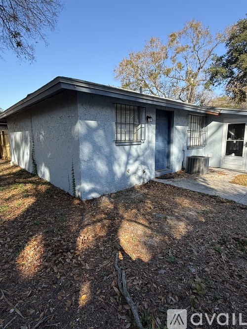 A small house with a grey exterior and a brown roof.