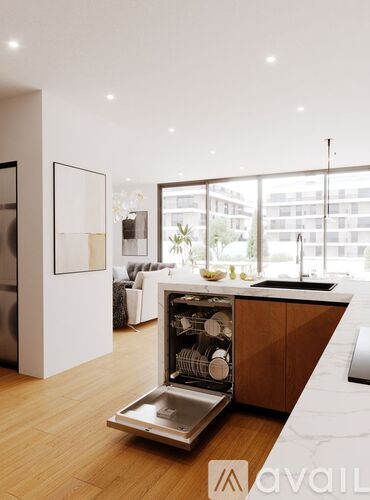 A modern kitchen with a large window and wooden flooring.