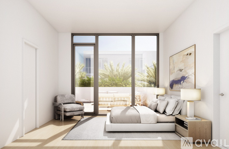 A modern bedroom with a large bed and a view of the outdoors through the sliding glass doors.