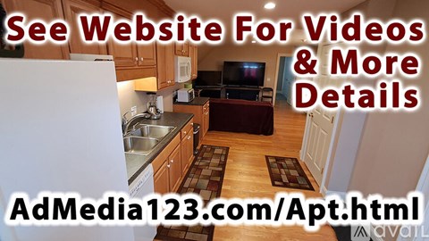A kitchen with a sink, refrigerator, and a television on the wall.