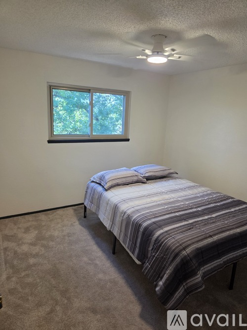 A bedroom with a bed and a window.