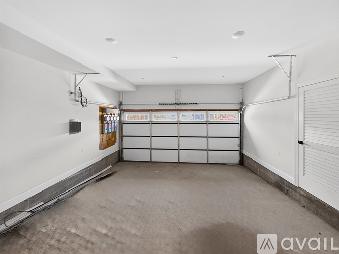 A spacious garage with a white wall and a white door.
