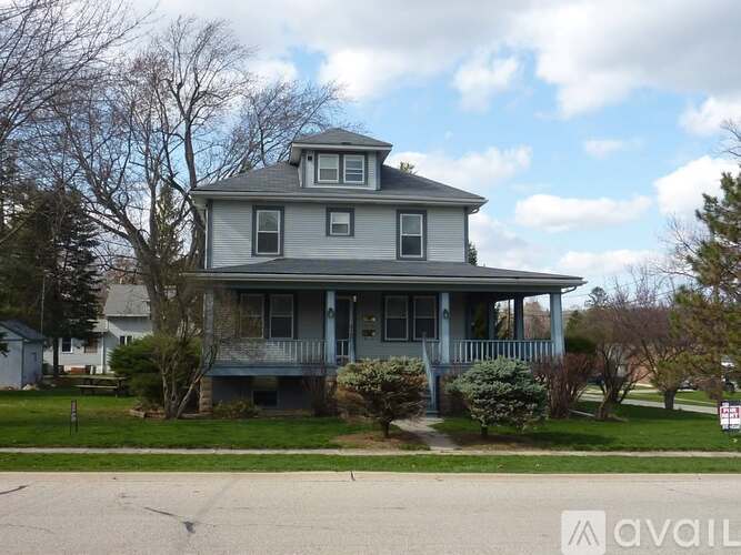 A two-story house with a porch and a balcony.