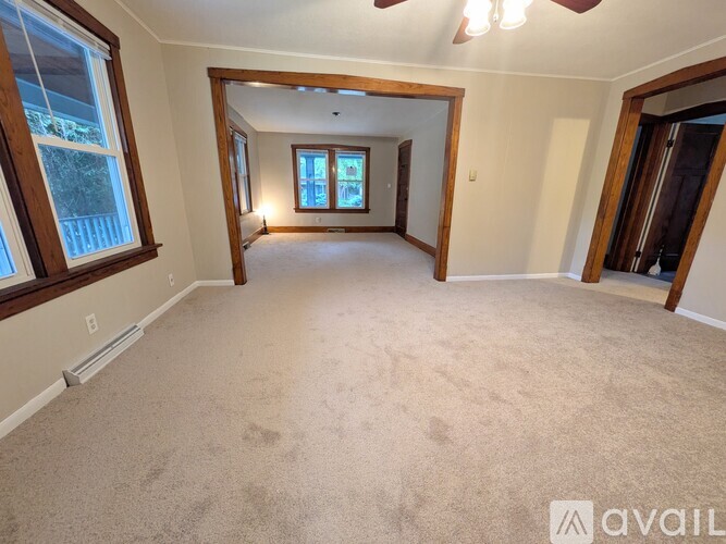 A spacious room with a carpeted floor and a large mirror on the wall.