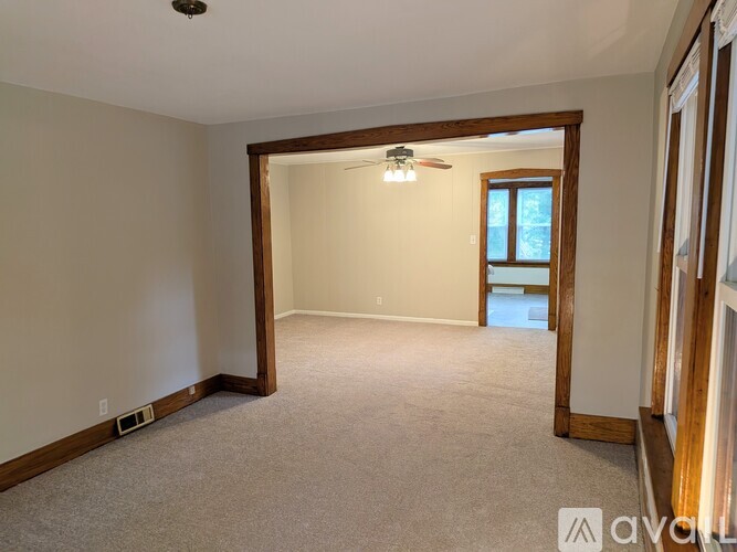 A room with a ceiling fan and a window.