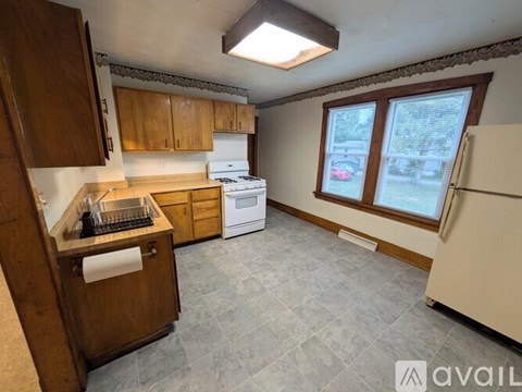 A kitchen with wooden cabinets and a tiled floor.