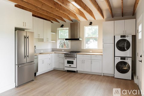 A kitchen with wooden ceiling and white cabinets.