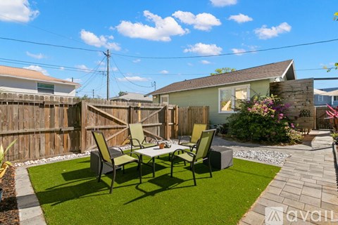 A backyard with a table and chairs set up on a lawn.