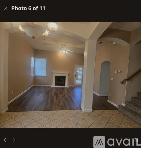 A living room with a fireplace and a staircase.