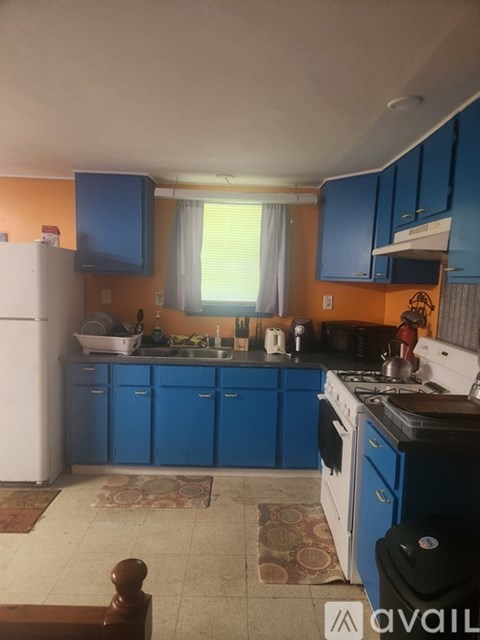 A kitchen with blue cabinets and a white refrigerator.