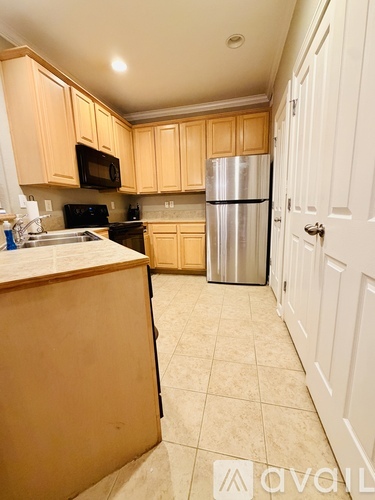 A kitchen with wooden cabinets and a stainless steel refrigerator.