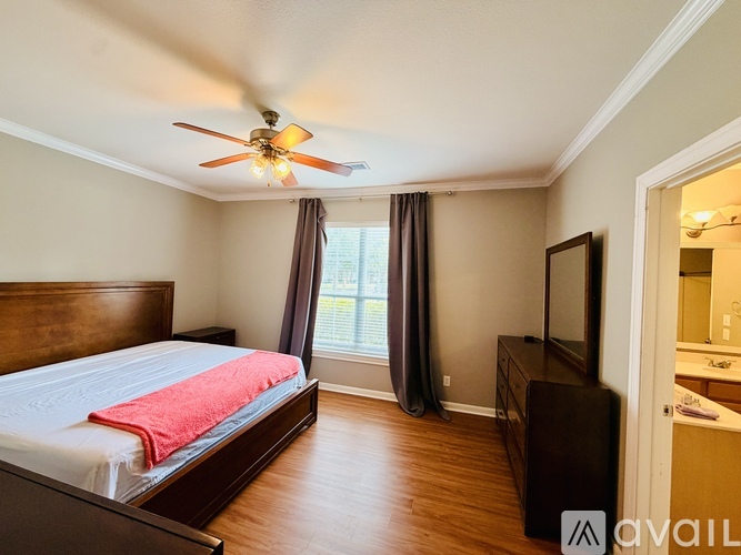 A bedroom with a bed, dresser, and television.