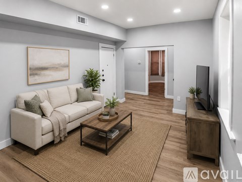 A living room with a couch, coffee table, and a painting on the wall.