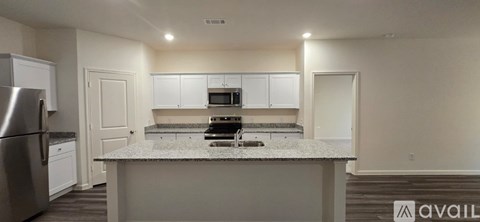 A kitchen with a granite countertop and stainless steel appliances.