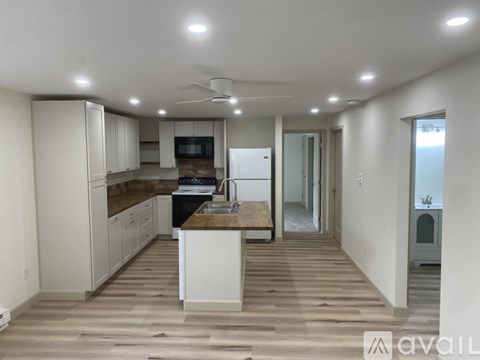 A kitchen with a wooden floor and white cabinets.