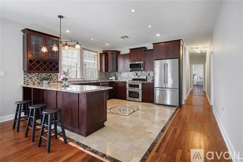 A kitchen with a bar area and a refrigerator.