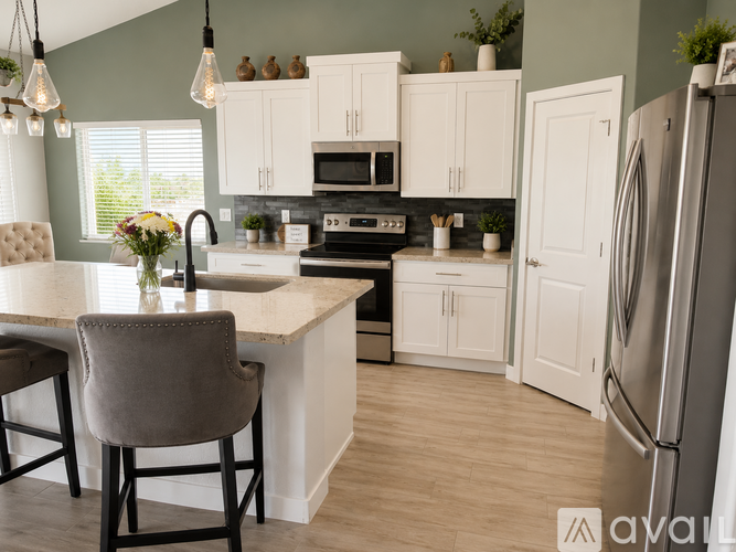 A kitchen with a white countertop and a grey chair.