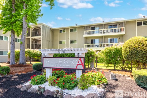 A sign for Allegra Student Apartments is in front of a building.