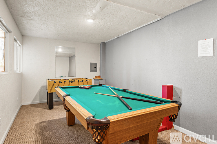 A pool table in a room with a carpet floor.