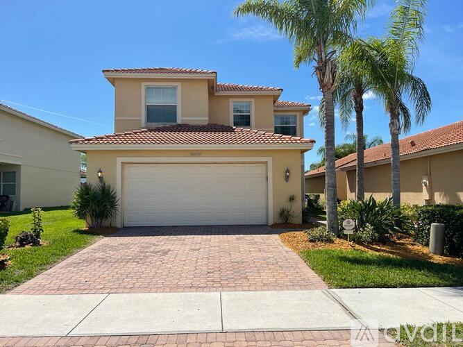 A house with a garage and a driveway in front of it.