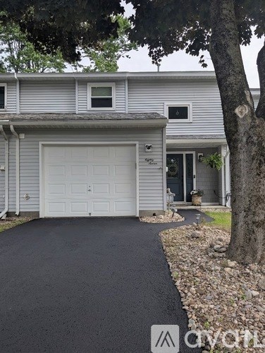 A house with a grey garage door and a driveway.