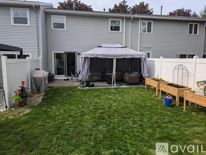A backyard with a patio and a gazebo.