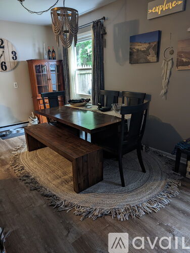 A dining room with a wooden table and chairs.