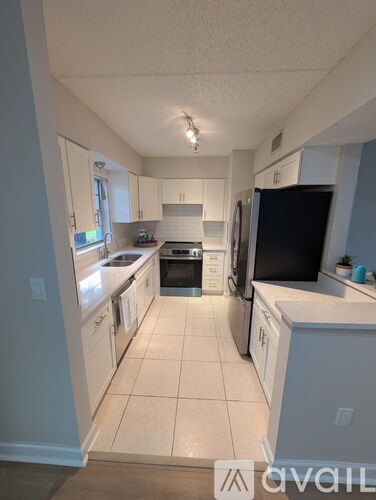 A kitchen with white cabinets and appliances.