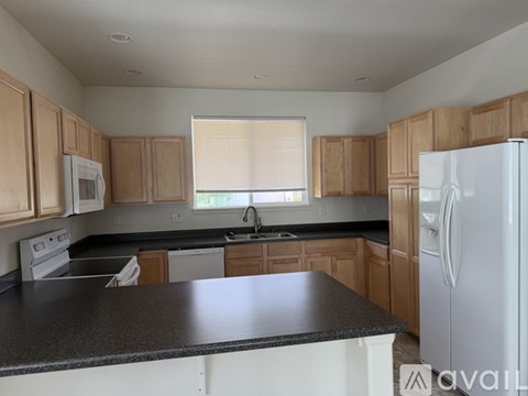 A kitchen with wooden cabinets and a black countertop.