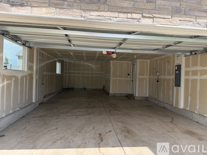 A spacious garage with a concrete floor and walls covered in insulation.