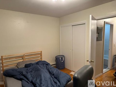 A bedroom with a bed, chair, and closet.