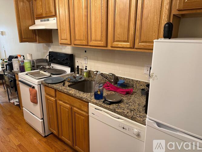 A kitchen with wooden cabinets and a white fridge.
