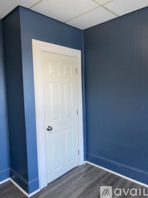A white door is in a room with blue walls.