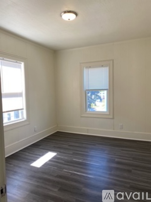 A room with a window and a picture on the wall.