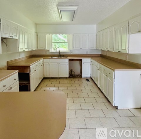 A kitchen with white cabinets and a brown countertop.