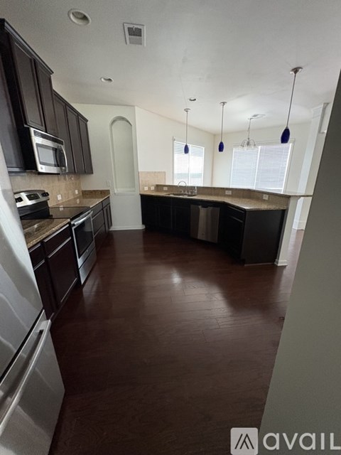 A kitchen with dark brown cabinets and a white refrigerator.