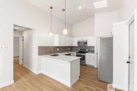 A modern kitchen with white cabinets and a wooden island.