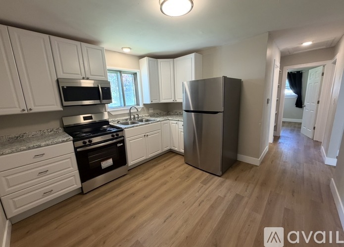 A kitchen with white cabinets and a stainless steel refrigerator.